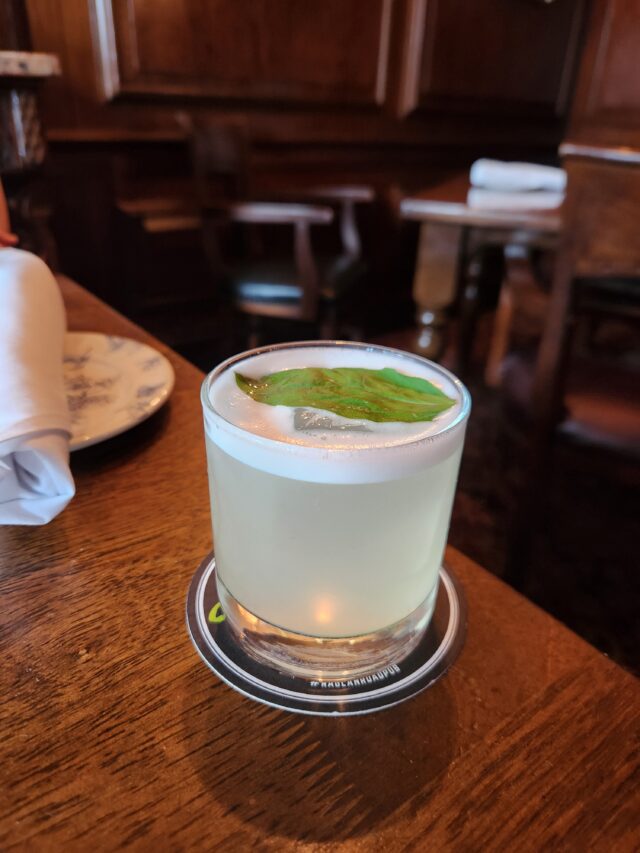 low cocktail glass with basil leaf on top of the cocktail